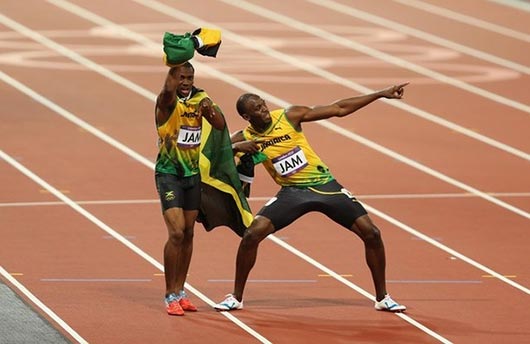  Usain Bolt, Yohan Blake, Michael Frater and Nesta Carter of Jamaica celebrate next to the clock after winning gold and setting a new world record of 36.84 during the Men's 4 x 100m Relay Final on Day 15 of the London 2012 Olympic Games at Olympic Stadium on August 11, 2012 in London, England.