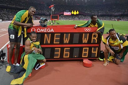  Usain Bolt, Yohan Blake, Michael Frater and Nesta Carter of Jamaica celebrate next to the clock after winning gold and setting a new world record of 36.84 during the Men's 4 x 100m Relay Final on Day 15 of the London 2012 Olympic Games at Olympic Stadium on August 11, 2012 in London, England.