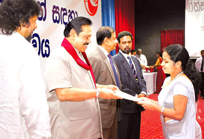 President Mahinda Rajapaksa presenting an appointment letter to a new recruit to the Sri Lanka Postal Service, at a ceremony at Temple Trees