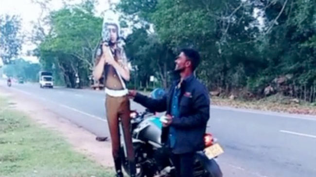 Pretending to give a bribe to a traffic Police cutout in Sri Lanka