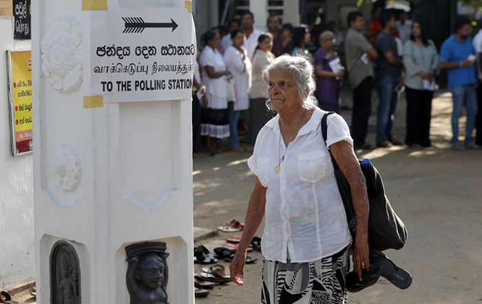 Sri Lankan elderly woman leaves after casting her vote