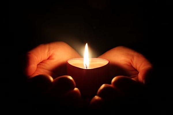 Candle on hand in dark