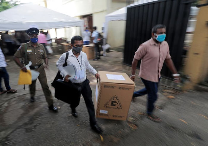 Sri Lankan police and election officials load ballot boxes in Colombo