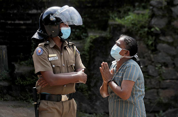 Sri Lanka Policeman stands near Mahara prison while clash in progress
