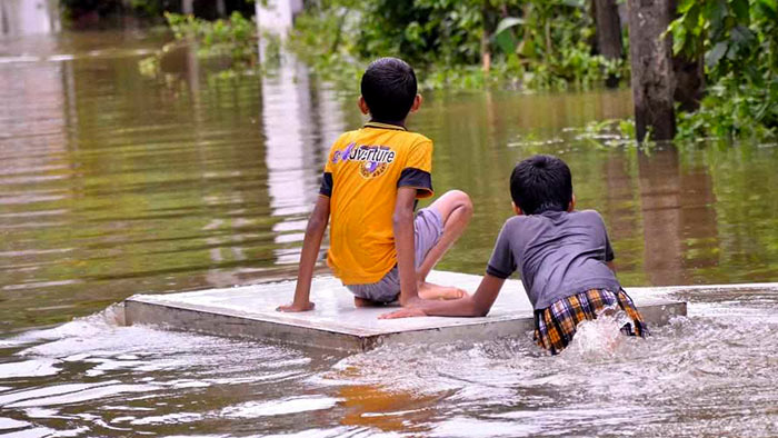 Children play on flooded roads in Gampaha, Sri Lanka