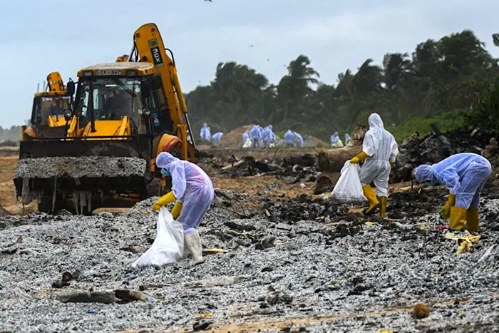 Sri Lankan Navy soldiers remove debris washed ashore from the ship MV X-Press Pearl