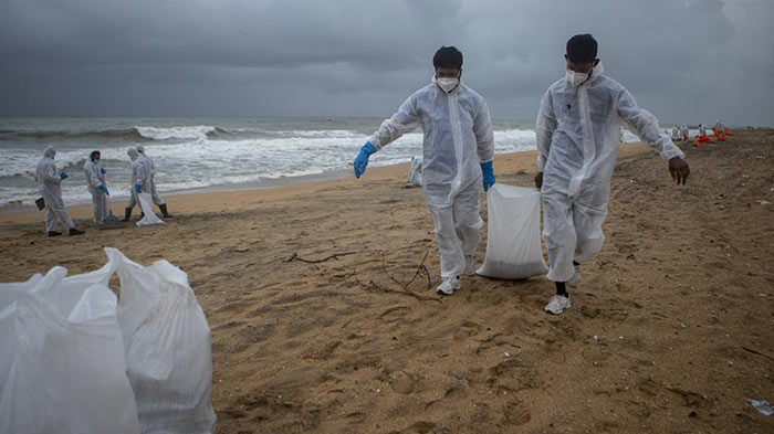 Sri Lankan Navy soldiers looking for plastic debris washed ashore from MV X-Press Pearl ship