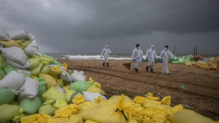 Sri Lankan Navy soldiers looking for plastic debris washed ashore from MV X-Press Pearl ship