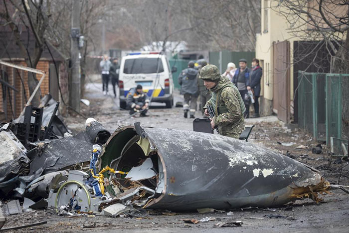 A Ukrainian Army soldier inspects fragments of a downed aircraft in Kyiv, Ukraine