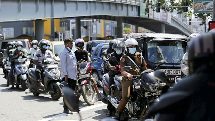 Vehicle owners wait in line to fill their tanks at a fuel station in Sri Lanka