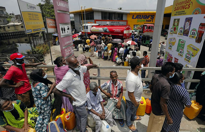 People stand in a long queue to buy kerosene oil at a fuel station in Colombo, Sri Lanka