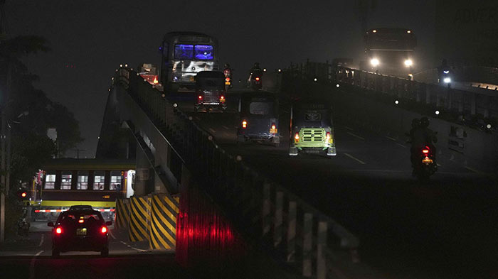 A train and vehicles roll in the dark during a power cut in Kelaniya, on the outskirts of Colombo, Sri Lanka