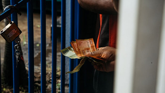 A resident holds Sri Lankan rupee notes in Colombo, Sri Lanka