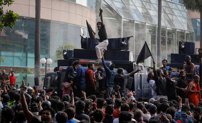 Protestors stand on a water cannon vehicle in Colombo, Sri Lanka