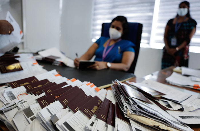 Officials prepare the passports of the applicants at the Sri Lanka's Immigration and Emigration Department