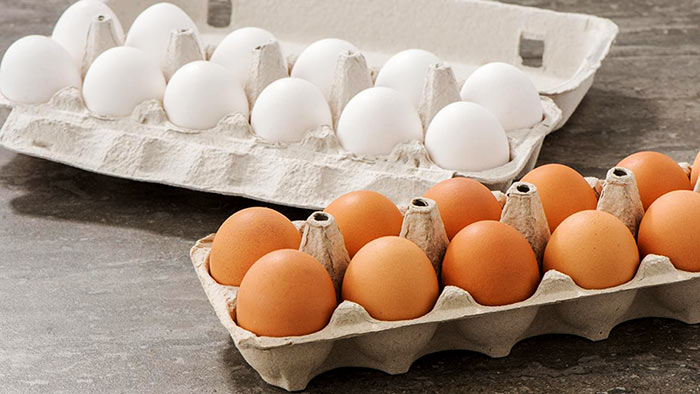 White and brown eggs in a carton