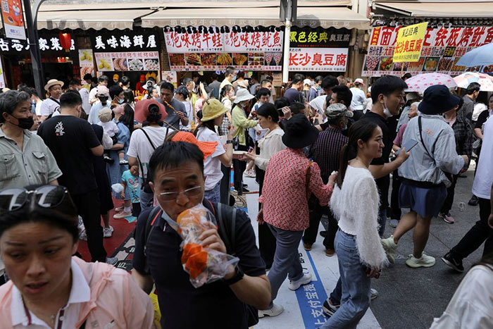 People crowd on a street during the Labour Day holiday in Wuhan, Hubei province, China