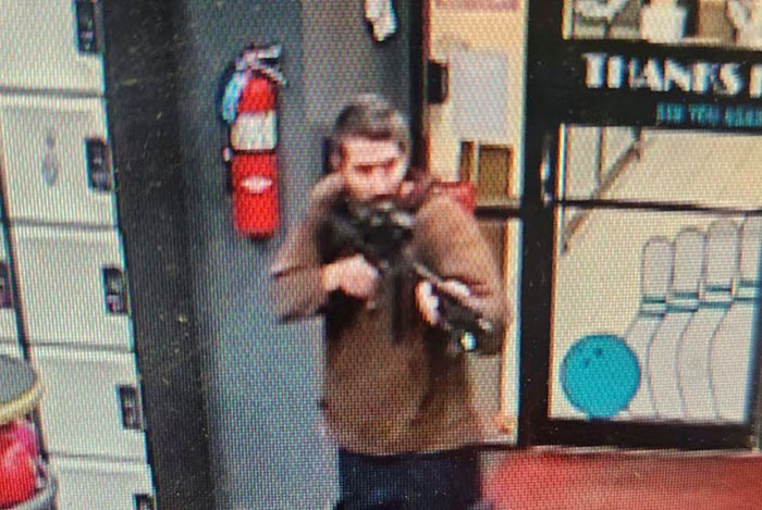 A man identified as a suspect by police points what appears to be a semiautomatic rifle, in Lewiston, Maine, United States