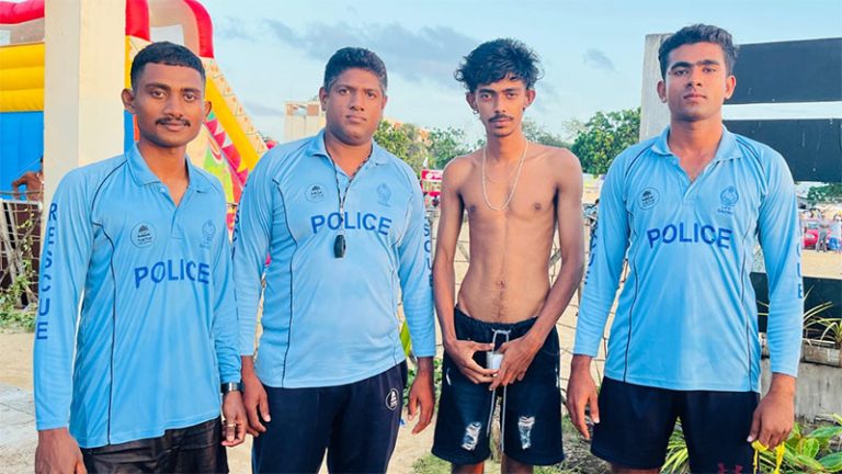 Three Sri Lanka Police lifeguards who rescued four swimmers at Eththukala beach stand with one of the rescued individuals