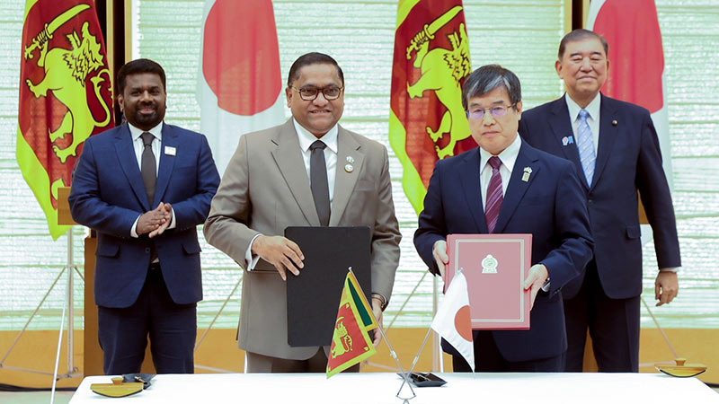 Minister Vijitha Herath exchanges documents with Japanese representative as Sri Lanka President Anura Kumara Dissanayake and Japan Prime Minister Shigeru Ishiba observe in Tokyo