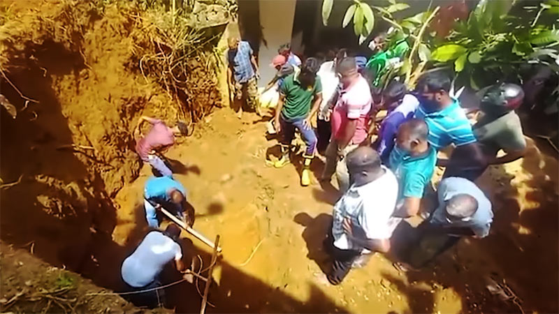 Rescue team using machinery to recover a trapped worker after retaining wall collapse in Mawanella
