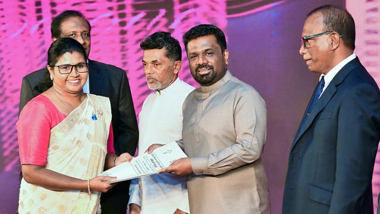 Sri Lanka President Anura Kumara Dissanayake presents a land deed to a woman at World Habitat Day ceremony