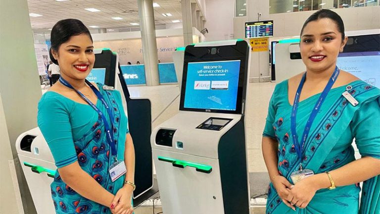 SriLankan Airlines female staff members standing in front of self check in kiosks at Bandaranaike International Airport (BIA) in Sri Lanka