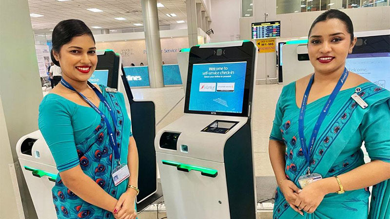 SriLankan Airlines female staff members standing in front of self check in kiosks at Bandaranaike International Airport (BIA) in Sri Lanka