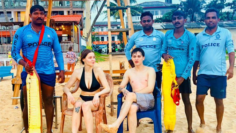 Belarusian couple posing with Sri Lanka Police Lifeguards after being rescued at Hikkaduwa Beach