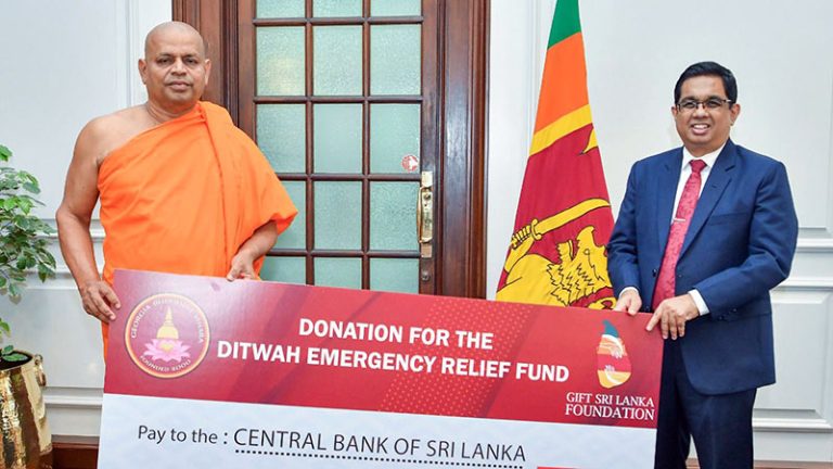 Most Venerable Panamwela Vajirabuddha Nayaka Thero, Chief Incumbent of the Georgia Buddhist Vihara, handing over a relief donation cheque to Secretary to the President Dr. Nandika Sanath Kumanayake