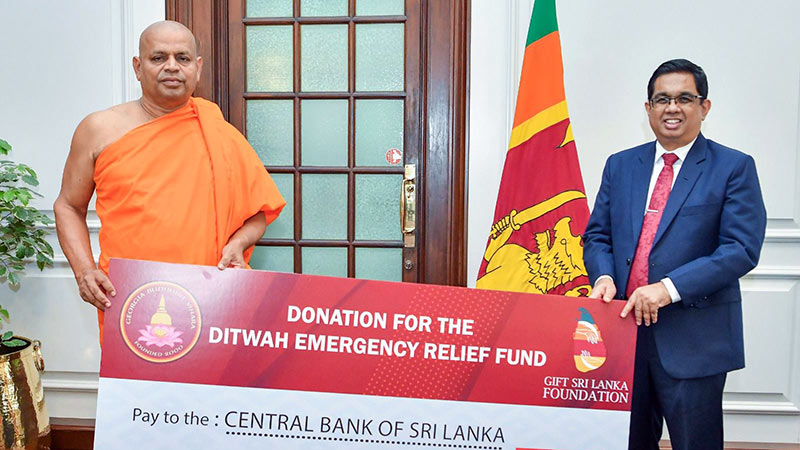 Most Venerable Panamwela Vajirabuddha Nayaka Thero, Chief Incumbent of the Georgia Buddhist Vihara, handing over a relief donation cheque to Secretary to the President Dr. Nandika Sanath Kumanayake