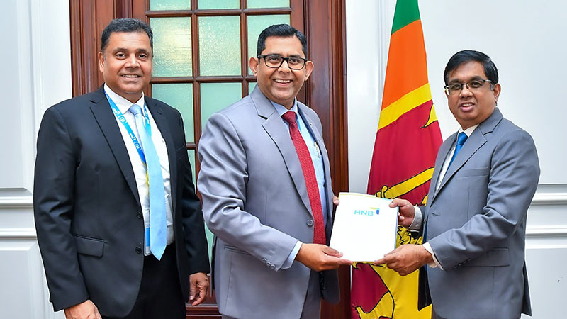 Hatton National Bank Managing Director and CEO Damith Pallewatte and COO Sanjaya Wijemanna present a Rs. 100 million cheque to Secretary to the President Dr. Nandika Sanath Kumanayake at the Presidential Secretariat in Colombo on December 16, 2025