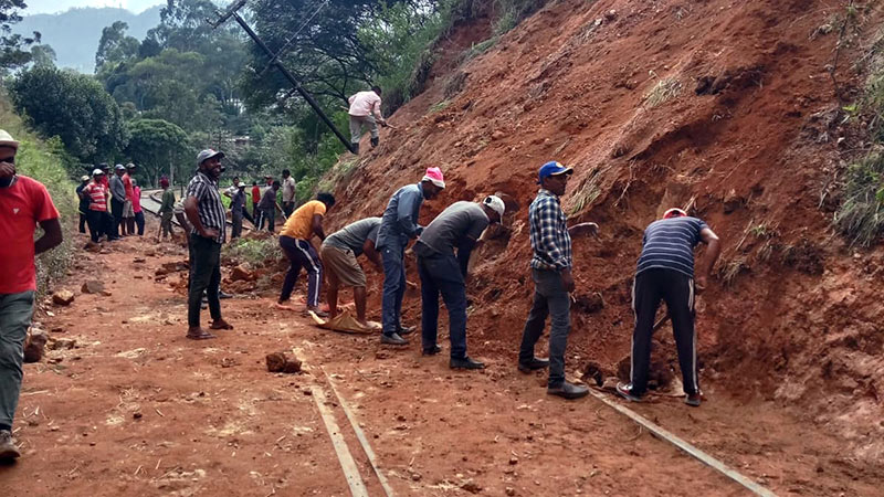 Workers clearing debris from a railway line in Sri Lanka damaged by landslides