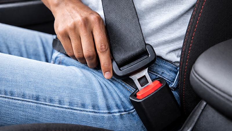 Close-up of a Sri Lankan person fastening a car seat belt