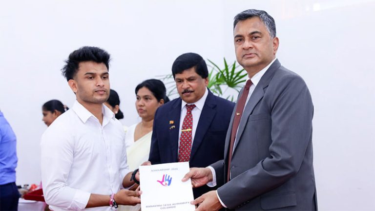 Sri Lanka Defence Secretary Air Vice Marshal Sampath Thuyacontha (Retd) awarding a scholarship certificate to a student during the Ranaviru Seva Authority ceremony