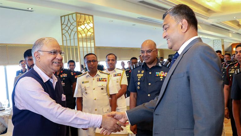 Indian High Commissioner Santosh Jha shakes hands with Sri Lanka Defence Secretary Sampath Thuyacontha at Colombo seminar