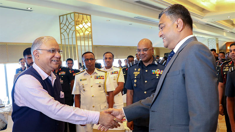 Indian High Commissioner Santosh Jha shakes hands with Sri Lanka Defence Secretary Sampath Thuyacontha at Colombo seminar