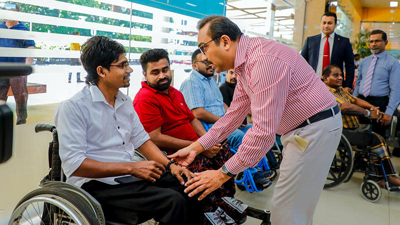 Minister Bimal Rathnayake speaks with a wheelchair user at the launch of Sri Lanka’s low-floor bus service pilot project in Makumbura