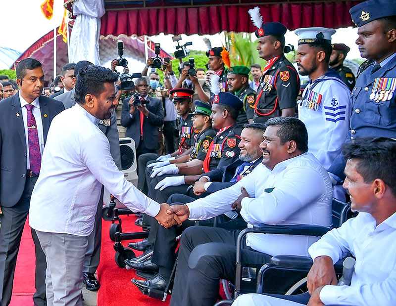 Sri Lanka President Anura Kumara Dissanayake shakes hands with a disabled war hero in a wheelchair at the National War Heroes’ Commemoration Day