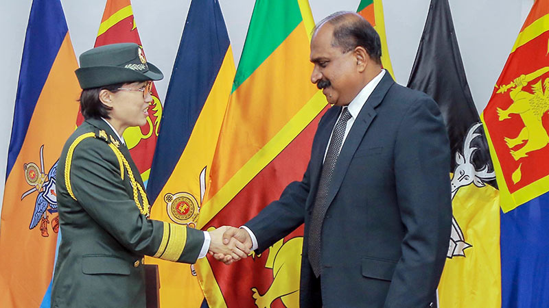 Deputy Minister of Defence Major General Aruna Jayasekara (Retd) greets Chinese Defence Attaché Senior Colonel Fu Xiao with a handshake during a courtesy call at the Ministry of Defence in Colombo