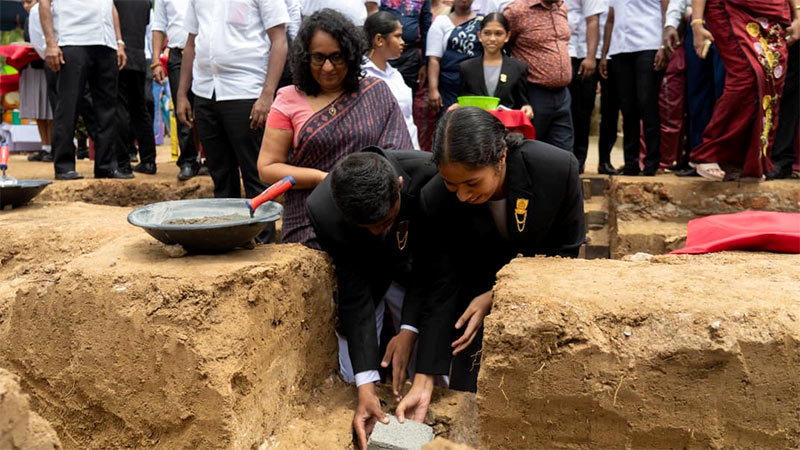 Two students lay the foundation stone for a new school building as Prime Minister Dr. Harini Amarasuriya looks on at Walaswewa Gunapala Malalasekara Model School in Maho