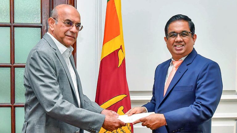 Retired Supreme Court Judge Priyantha Fernando receiving his appointment document from Secretary to the President Dr. Nandika Sanath Kumanayake