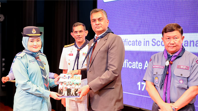 Defence Secretary Air Vice Marshal Sampath Thuyacontha presenting a certificate to a female Scout official at the KDU ceremony