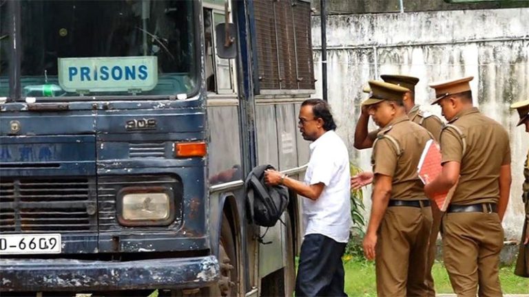 Sarath Weerawansa boards a prison bus after appearing in court