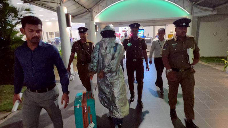 Suspect arrested over Akuregoda lawyer and wife murder escorted by Sri Lanka Police at Bandaranaike International Airport in Katunayake