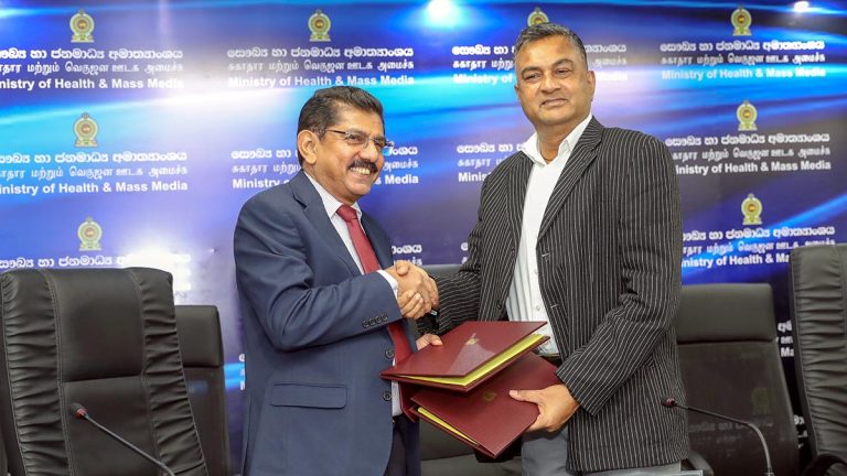 Defence Secretary Sampath Thuyacontha and Health Ministry Secretary Anil Jasinghe exchange signed agreements and shake hands