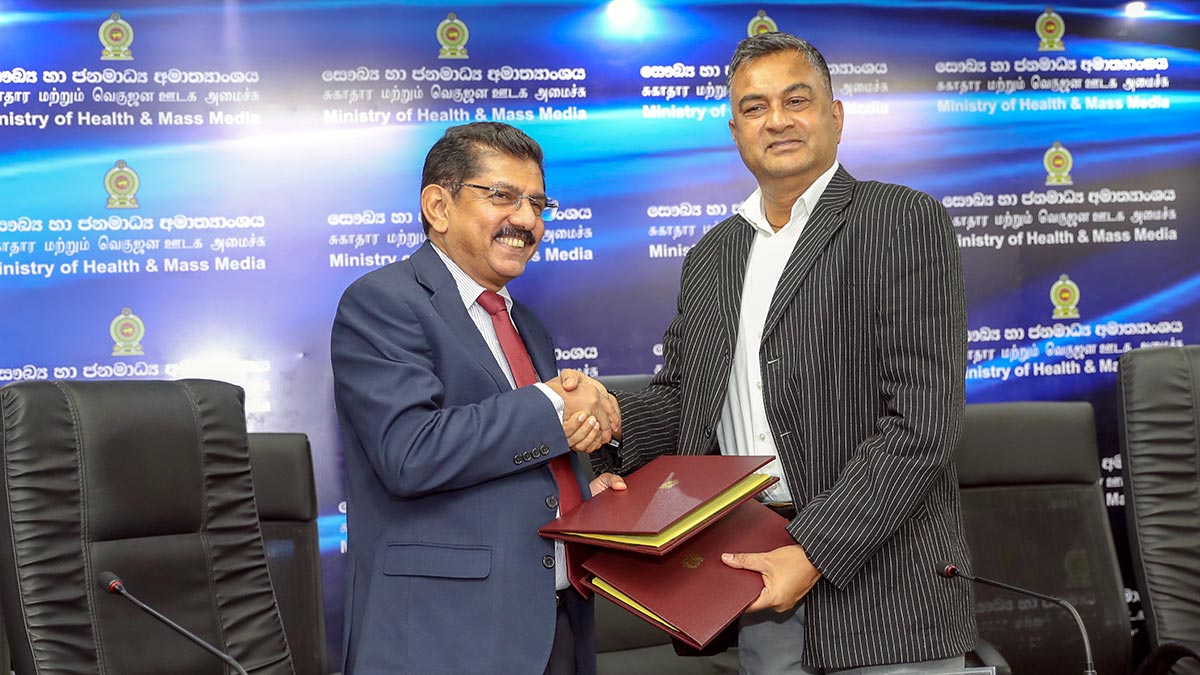 Defence Secretary Sampath Thuyacontha and Health Ministry Secretary Anil Jasinghe exchange signed agreements and shake hands