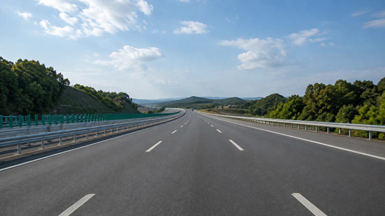 Empty expressway stretching through a green landscape