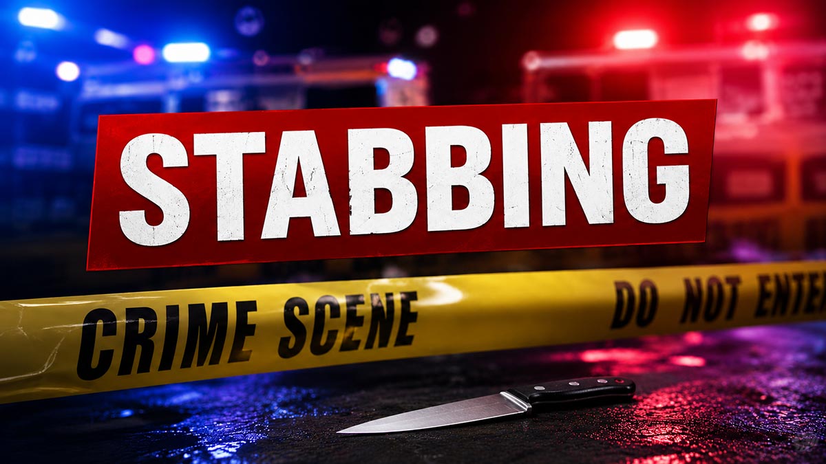 Knife at a stabbing crime scene with police lights and crime scene tape