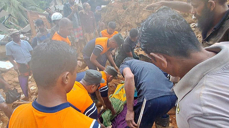 Sri Lanka Army personnel recover the body of an 82-year-old woman after a landslide buried a house in Polpitiya